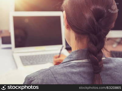 Business woman at work, back side of a woman working on the laptop, working in the office, young successful people concept