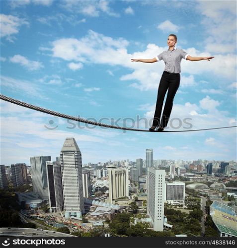 Business woman balancing high over a cityscape