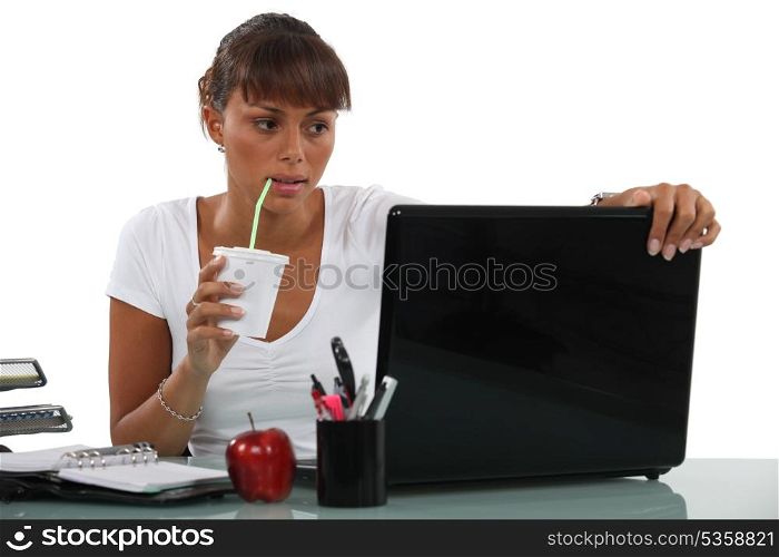 Business woman drinking at desk