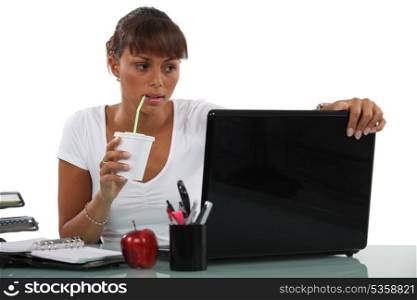 Business woman drinking at desk
