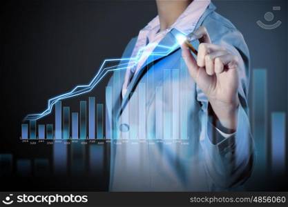 Business woman drowing media graphs. Image of businesswoman in grey suit drawing graph