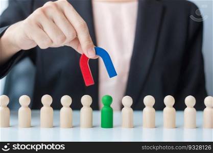 Business woman hand holding magnet and pulling man wooden figure from the crowd employee. Business, Human resource management, Recruitment, Teamwork, strategy, toxic people and leadership Concepts