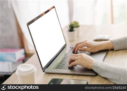 Business woman hand typing laptop computer on wooden table