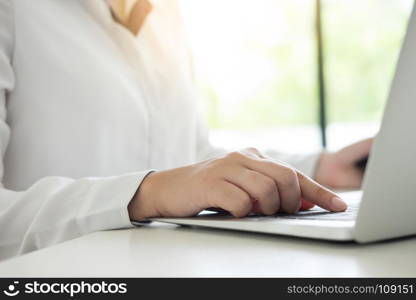 Business woman hand typing on laptop keyboard and using tablet for working