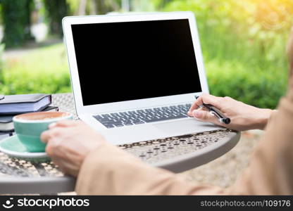 business woman hand using laptop on table in garden