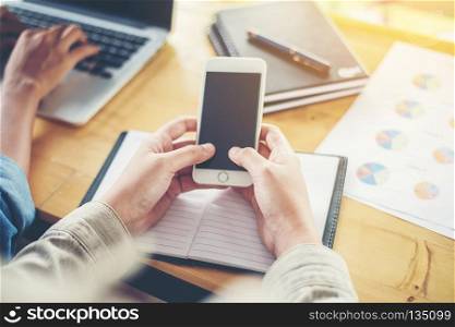 business woman hand working on smart phone with business graph . business woman hand working on smart phone with business graph information diagram on wooden table.