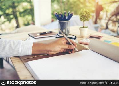 Business woman hands writing on notebook. Work outdoor.