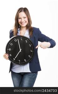 Business woman holding a big clock and pointing to him, isolated over white background
