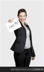 Business woman holding a card board with the text message  Hire me 