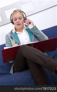 Business woman holding a dossier whilst making a conference call using a head set and microphone
