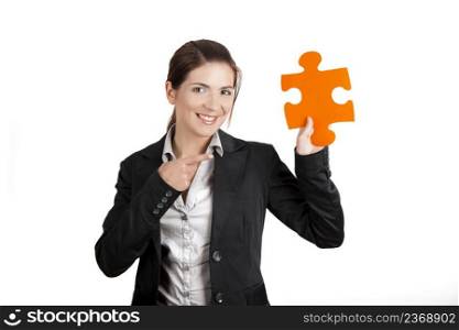 Business woman holding and pointing to a puzzle piece, isolated on white