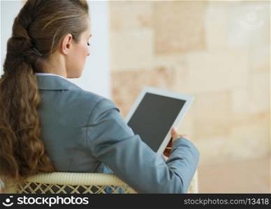 Business woman holding tablet PC. Rear view