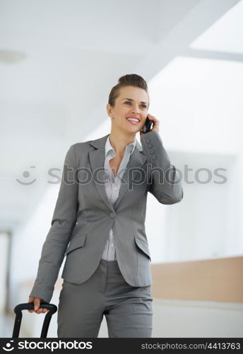 Business woman in business trip with bag speaking mobile