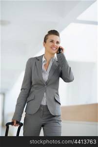 Business woman in business trip with bag speaking mobile