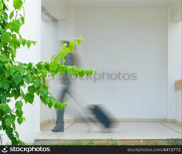 Business woman in business trip with wheel bag. Motion blurred