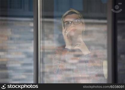 business woman in meeting room speaking by cell phone, people groupbrainstorming in background