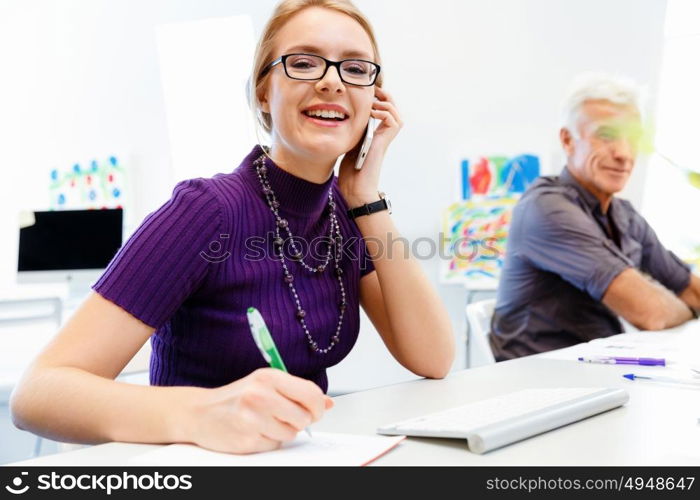 Business woman in office holding mobile phone. Young business woman in office holding mobile phone