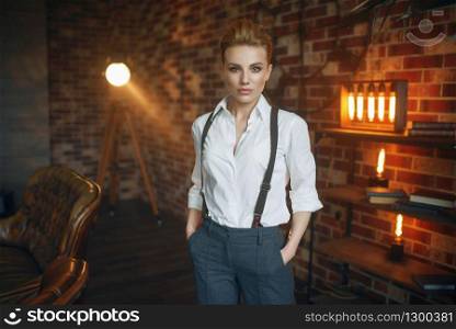 Business woman in strict clothes poses in studio, retro fashion, gangster style, mafia. Vintage lady in office with brick walls. Woman in strict clothes, gangster style, mafia