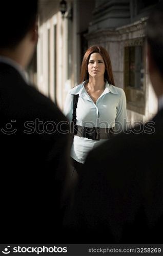 Business woman interacting with businessmen, outdoors