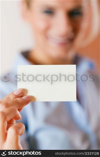 Business woman is handing her business card over ? focus on the card