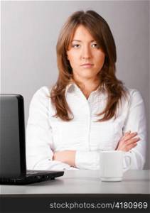 business woman is sitting in the office with laptop