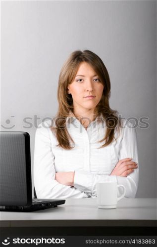 business woman is sitting in the office with laptop