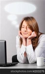 business woman is sitting in the office with laptop and dreaming with head on hands