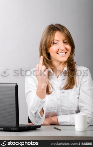 business woman is sitting in the office with laptop and showing middle finger