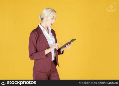 Business woman is surprising in studio yellow background