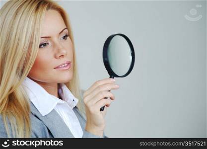 business woman looking through a magnifying glass