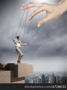 Business woman marionette. Businesswoman marionette on ropes controlled by puppeteer against city background