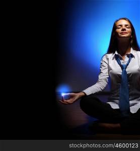 Business woman meditating. Young business woman sitting in asana lotus and meditating