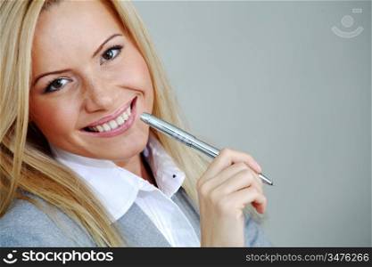 business woman on gray background pen in hands