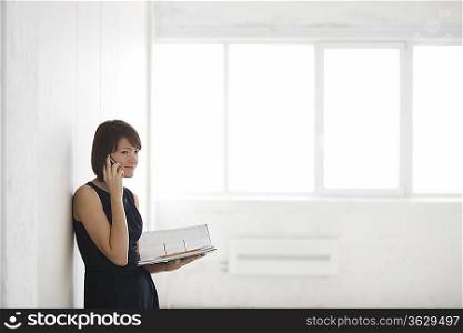 Business woman on holding file in empty warehouse
