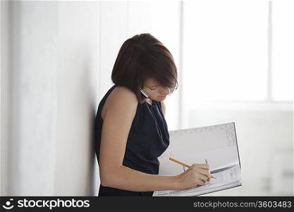Business woman on making notes in empty warehouse