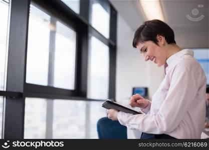 business woman on meeting usineg tablet computer, blured group of people in background at modern bright startup office interior