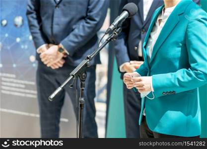 Business woman or female politician is giving a speech at media event