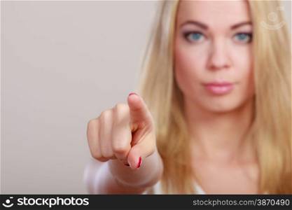 Business woman pointing with finger at you on gray