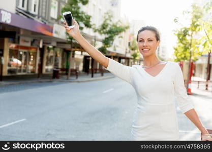 Business woman pulling suitcase bag walking in city. Young business woman with suitcase in city looking for taxi