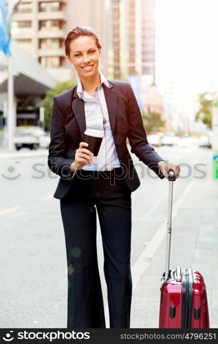 Business woman pulling suitcase walking in city. Young business woman pulling suitcase walking in urban city