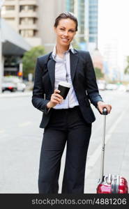 Business woman pulling suitcase walking in city. Young business woman pulling suitcase walking in urban city