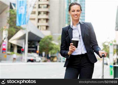Business woman pulling suitcase walking in city. Young business woman pulling suitcase walking in urban city