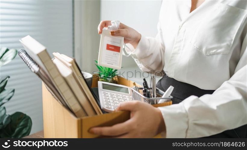 Business woman sending resignation letter and packing Stuff Resign Depress or carrying business cardboard box by desk in office. Change of job or fired from company.