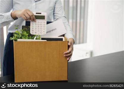 Business woman sending resignation letter and packing Stuff Resign Depress or carrying business cardboard box by desk in office. Change of job or fired from company