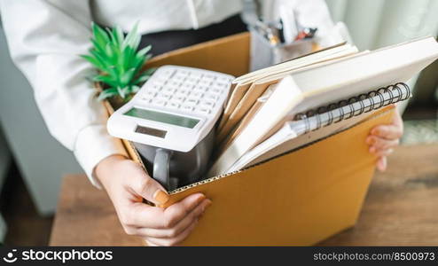 Business woman sending resignation letter and packing Stuff Resign Depress or carrying business cardboard box by desk in office. Change of job or fired from company.