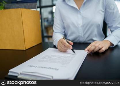 Business woman sending resignation letter to boss and Holding Stuff Resign Depress or carrying cardboard box by desk in office.