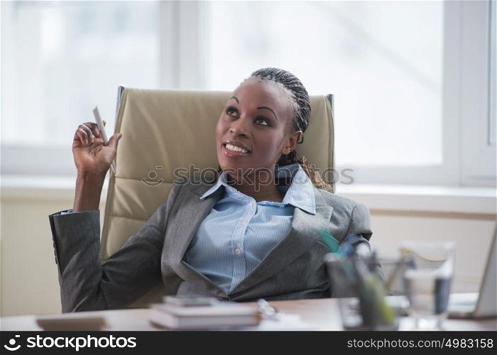 Business woman sitting in armchair at office and planning