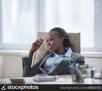 Business woman sitting in armchair at office and planning