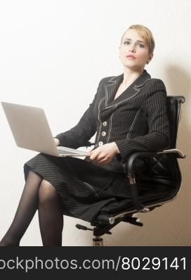 Business woman sitting on chair with notebook in office