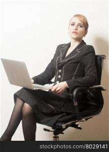 Business woman sitting on chair with notebook in office